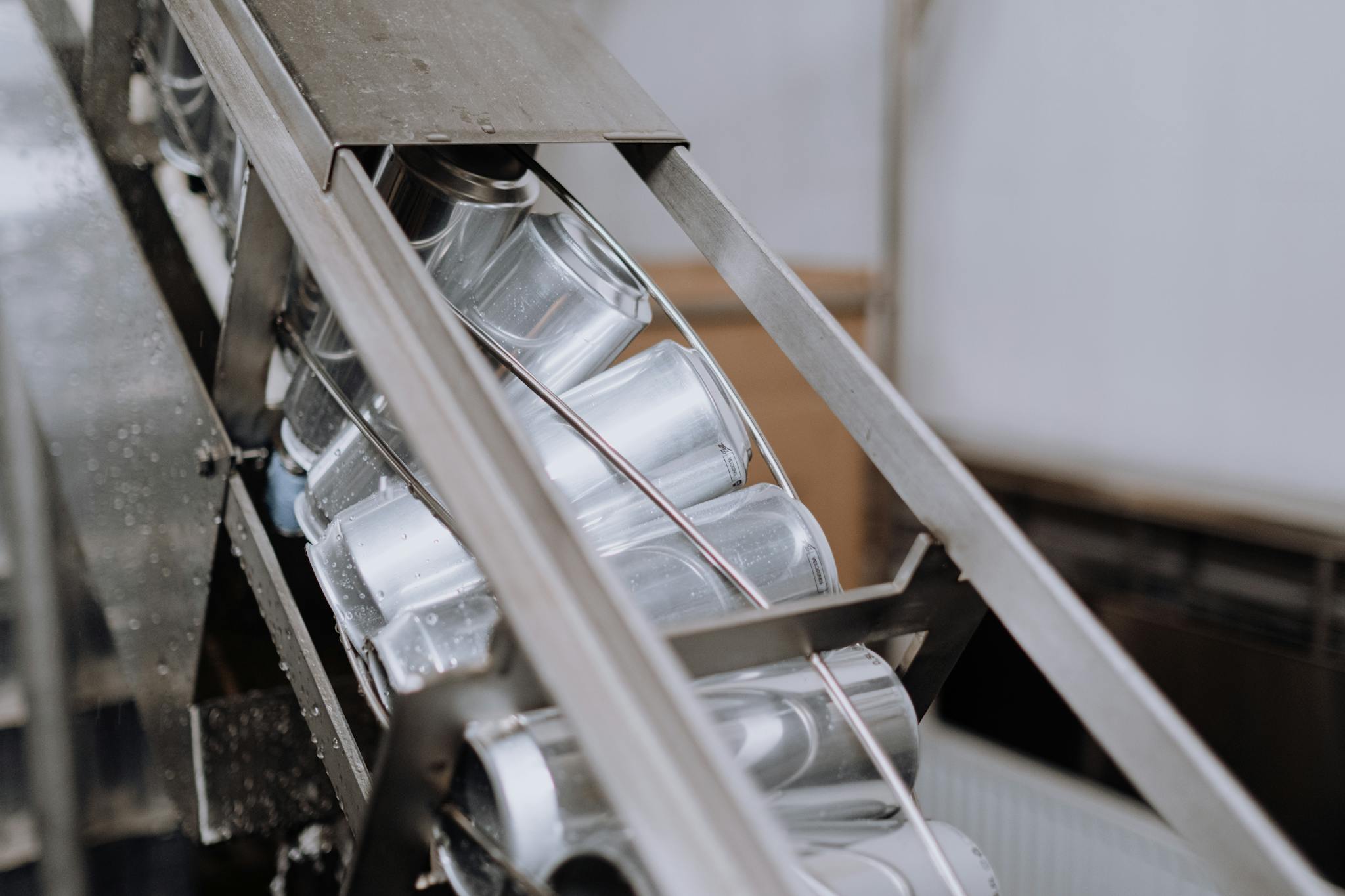 Close-up of automated canning equipment in a brewery showcasing production efficiency.