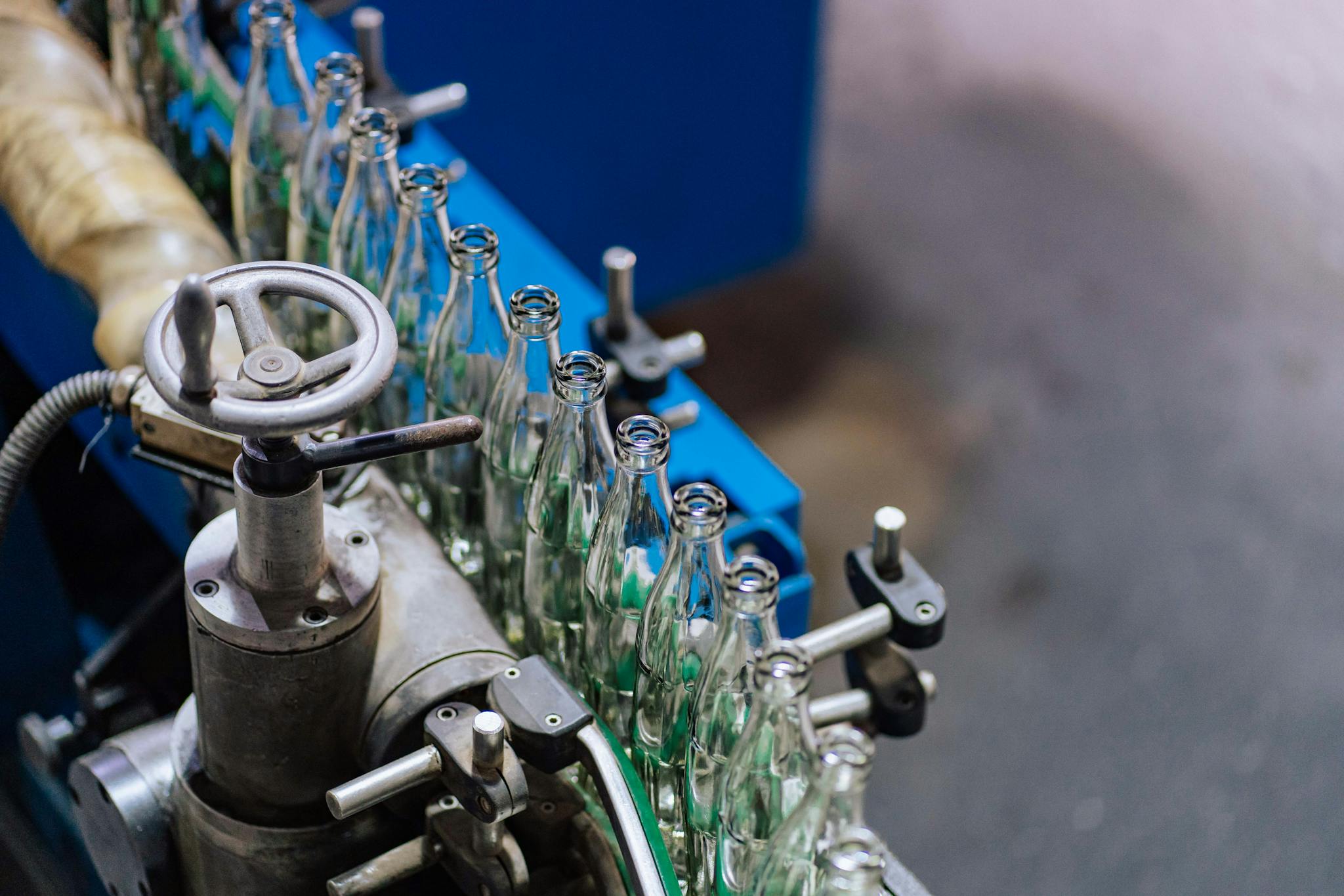 Close-up of glass bottling machinery in action, showcasing industrial precision.
