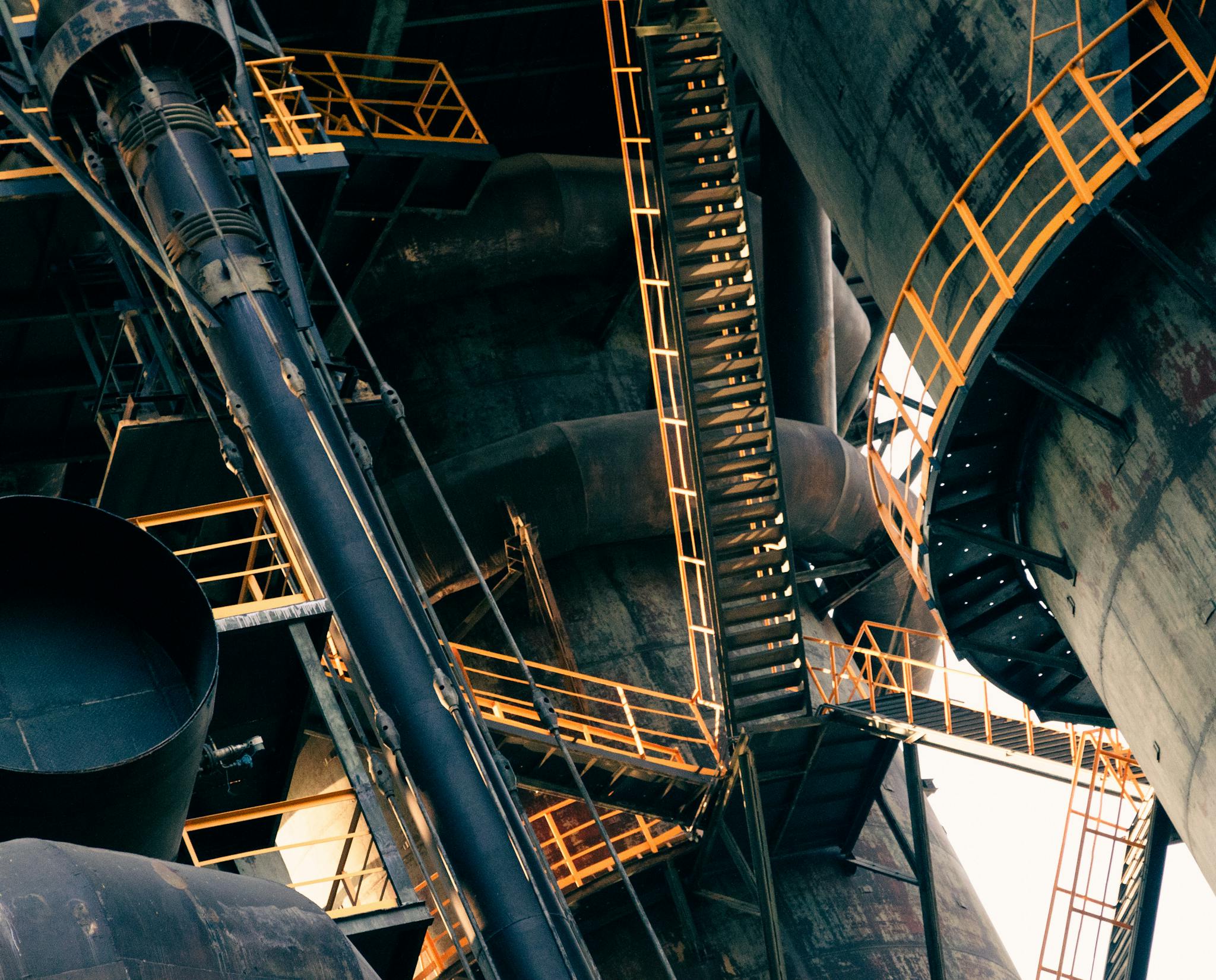 Intricate view of metal stairs and structures in a large industrial facility.