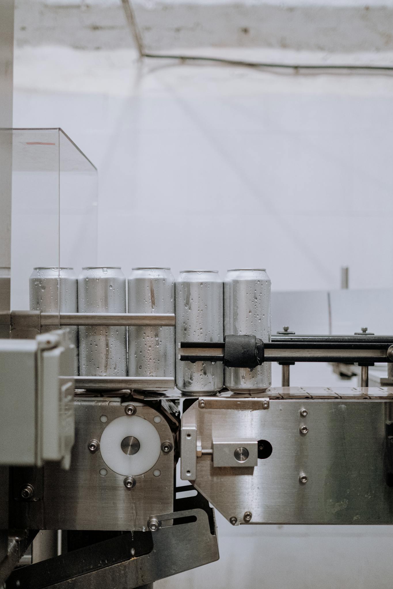 Vertical shot of aluminum cans on a conveyor in a factory setting, showcasing industrial processes.